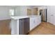Kitchen island featuring stainless steel dishwasher, ample cabinet space and a view to other room at 740 Pineberry Ct, Grayson, GA 30017