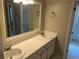 Bathroom with dual sinks, white countertops, and white cabinets with a large mirror at 1093 Hasty Sw Ct, Lilburn, GA 30047