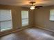 Bedroom with neutral carpet and walls, featuring large windows and ceiling fan with light at 1093 Hasty Sw Ct, Lilburn, GA 30047