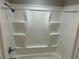 Bathroom shower with white seamless shower surround, silver hardware, and built-in shelving at 1093 Hasty Sw Ct, Lilburn, GA 30047
