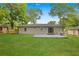 Backyard featuring newly built gray brick wall and porch surrounded by lush green grass at 1770 Atherton Dr, Decatur, GA 30035