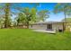 Large backyard with lush green grass and a newly built gray brick wall and porch at 1770 Atherton Dr, Decatur, GA 30035