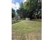 Expansive backyard with lush grass, a small shed, and mature trees providing privacy and shade at 2303 Condor Dr, Lawrenceville, GA 30044