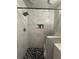Shower features marble tile, a rainfall showerhead, and a built-in niche for toiletries for spa experience at 2303 Condor Dr, Lawrenceville, GA 30044