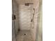 Walk in shower with wave-like tile and grey stone floor at 2303 Condor Dr, Lawrenceville, GA 30044