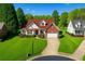 Charming brick home featuring lush landscaping, a two-car garage, and a well-manicured lawn at 3076 Harris Mill Ct, Duluth, GA 30096
