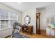 Bright home office features a desk, antique clock, and treadmill for at home workouts at 3076 Harris Mill Ct, Duluth, GA 30096