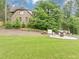 Expansive backyard featuring a lush lawn, mature trees, and a stone fire pit area for outdoor enjoyment at 3459 Clubland Dr, Marietta, GA 30068