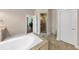 Bright bathroom features a soaking tub and glass-enclosed shower with neutral stone tile and fixtures at 3459 Clubland Dr, Marietta, GA 30068