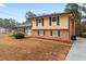 Charming two-story home with a brick and yellow siding, surrounded by mature trees and a well-maintained lawn at 2002 Twin Falls Rd, Decatur, GA 30032