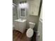 Bathroom featuring a toilet, single sink vanity, storage, and tub shower combo with glass door at 2266 Eastgate Dr, Snellville, GA 30078