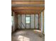 An empty room with light metal walls, a plywood floor, a metal roof, exposed beams and a small window at 2266 Eastgate Dr, Snellville, GA 30078