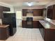 Well-lit kitchen with dark cabinets, neutral countertops and modern appliances at 3551 Skyline Sw Ter, Marietta, GA 30008
