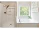 Bathroom featuring a large tub, a glass enclosed shower and a window at 4630 Smokestone Dr, Douglasville, GA 30135