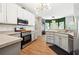 Well-equipped kitchen with white cabinets, stainless steel appliances, and modern lighting at 4630 Smokestone Dr, Douglasville, GA 30135