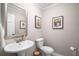 Clean half-bathroom with pedestal sink, toilet, and framed mirror at 1560 Boxwood Nw Trce, Acworth, GA 30102