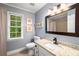 Classic bathroom featuring a granite countertop vanity, mirror, toilet, shower and natural light from window at 1560 Boxwood Nw Trce, Acworth, GA 30102