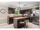 Well-lit kitchen with stainless steel refrigerator, eat-in island and dark wood cabinets at 1560 Boxwood Nw Trce, Acworth, GA 30102