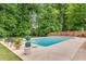 Backyard featuring in-ground swimming pool surrounded by lush green trees at 1560 Boxwood Nw Trce, Acworth, GA 30102