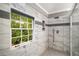 Walk-in shower featuring marble-look tile, a rain shower head, and a window providing natural light at 1560 Boxwood Nw Trce, Acworth, GA 30102