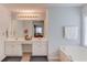 Bright bathroom featuring double vanity, large mirror with Hollywood lights, and a soaking tub at 2990 Haynes Club Cir, Grayson, GA 30017