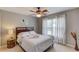 Bedroom with ceiling fan, bed with white linens and bedside table with table lamp and wall decor at 2990 Haynes Club Cir, Grayson, GA 30017