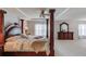 Elegant main bedroom with a four-poster bed, dresser, and a seating area providing ample space at 2990 Haynes Club Cir, Grayson, GA 30017