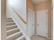 Carpeted staircase with wooden handrail leading to the upper level, with doors for storage or rooms at 2990 Haynes Club Cir, Grayson, GA 30017
