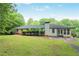 View of backyard showing an exterior elevation of the home, a chimney, and a lush lawn at 4025 Cheoah Dr, Douglasville, GA 30135