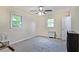 Neutral bedroom featuring a ceiling fan, two windows, and gray carpeting at 4025 Cheoah Dr, Douglasville, GA 30135