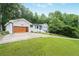 The exterior of this home features a modern garage door and a well-maintained lawn at 4025 Cheoah Dr, Douglasville, GA 30135