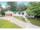 This is a view of the home exterior showing a modern garage and landscaped front yard at 4025 Cheoah Dr, Douglasville, GA 30135