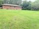 Large grassy backyard with a brick house and some trees offering a serene view at 5167 Hiram Lithia Springs Rd, Powder Springs, GA 30127