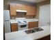 Well-lit kitchen with wooden cabinets, white countertops and stainless steel sink at 8202 Fairington Village Dr, Lithonia, GA 30038