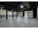 Unfinished basement with concrete floor, black support beams, and overhead garage doors at 3427 Mill Stream Sw Ln, Marietta, GA 30060
