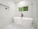Bright bathroom features a soaking tub, window, mosaic tiled floors, and glass shower at 3427 Mill Stream Sw Ln, Marietta, GA 30060