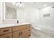 Bright bathroom with wood vanity, quartz countertop, modern fixtures, and white tiled shower at 3427 Mill Stream Sw Ln, Marietta, GA 30060