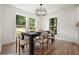 Bright dining room featuring wood floors, black table with seating for six, and modern lighting at 3427 Mill Stream Sw Ln, Marietta, GA 30060