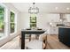 Dining area featuring large windows, a stylish light fixture, and easy access to the modern kitchen at 3427 Mill Stream Sw Ln, Marietta, GA 30060