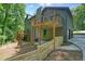 View of home's exterior featuring the wooden porch, matching rails, and a backyard with a wooden fence at 3427 Mill Stream Sw Ln, Marietta, GA 30060