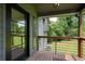 Covered porch featuring wood floors, metal railing, and a view of the lush greenery surrounding the property at 3427 Mill Stream Sw Ln, Marietta, GA 30060