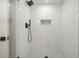 White tiled shower featuring sleek black fixtures, a glass door, and a mosaic-tiled floor at 3427 Mill Stream Sw Ln, Marietta, GA 30060
