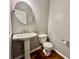 Bathroom features a white pedestal sink, white toilet, and hardwood floors at 3988 Church View Ln, Suwanee, GA 30024