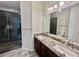 Bathroom featuring double sinks, large mirrors, and a tiled shower at 3988 Church View Ln, Suwanee, GA 30024