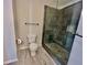 Modern bathroom featuring a sleek glass shower with dark ceramic tiles, toilet, and chrome towel rack at 3988 Church View Ln, Suwanee, GA 30024