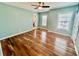 Bedroom featuring hardwood floors, ceiling fan, three windows, and two entry doors at 3988 Church View Ln, Suwanee, GA 30024