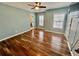 Bedroom featuring hardwood floors, ceiling fan, three windows, and two entry doors at 3988 Church View Ln, Suwanee, GA 30024