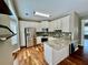 Open kitchen with a center island, stainless steel appliances, white cabinets, and wood flooring at 3988 Church View Ln, Suwanee, GA 30024