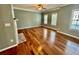 Spacious living room featuring hardwood floors, a ceiling fan, and natural light from large windows at 3988 Church View Ln, Suwanee, GA 30024