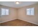 Neutral-toned bedroom with refinished floors and natural light from the two windows at 80 Crystal River Dr, Riverdale, GA 30274